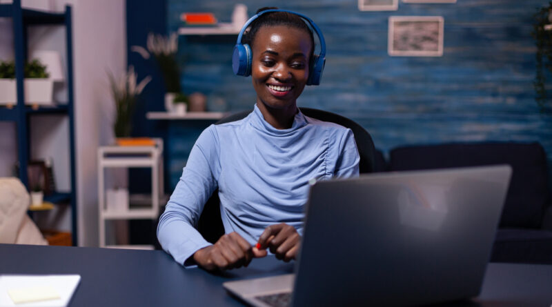 Mulher negra digita na frente de um notebook