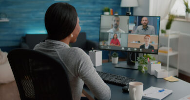 Mulher negra assiste reunião online na tela do computador