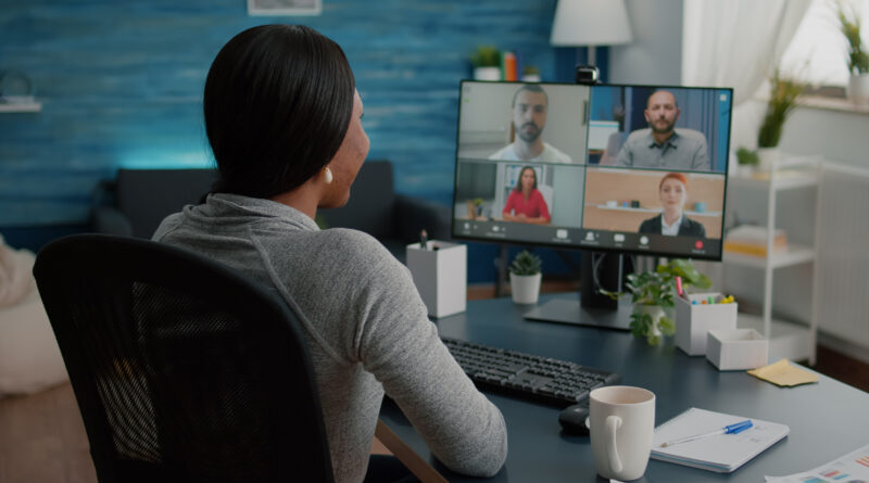 Mulher negra assiste reunião online na tela do computador
